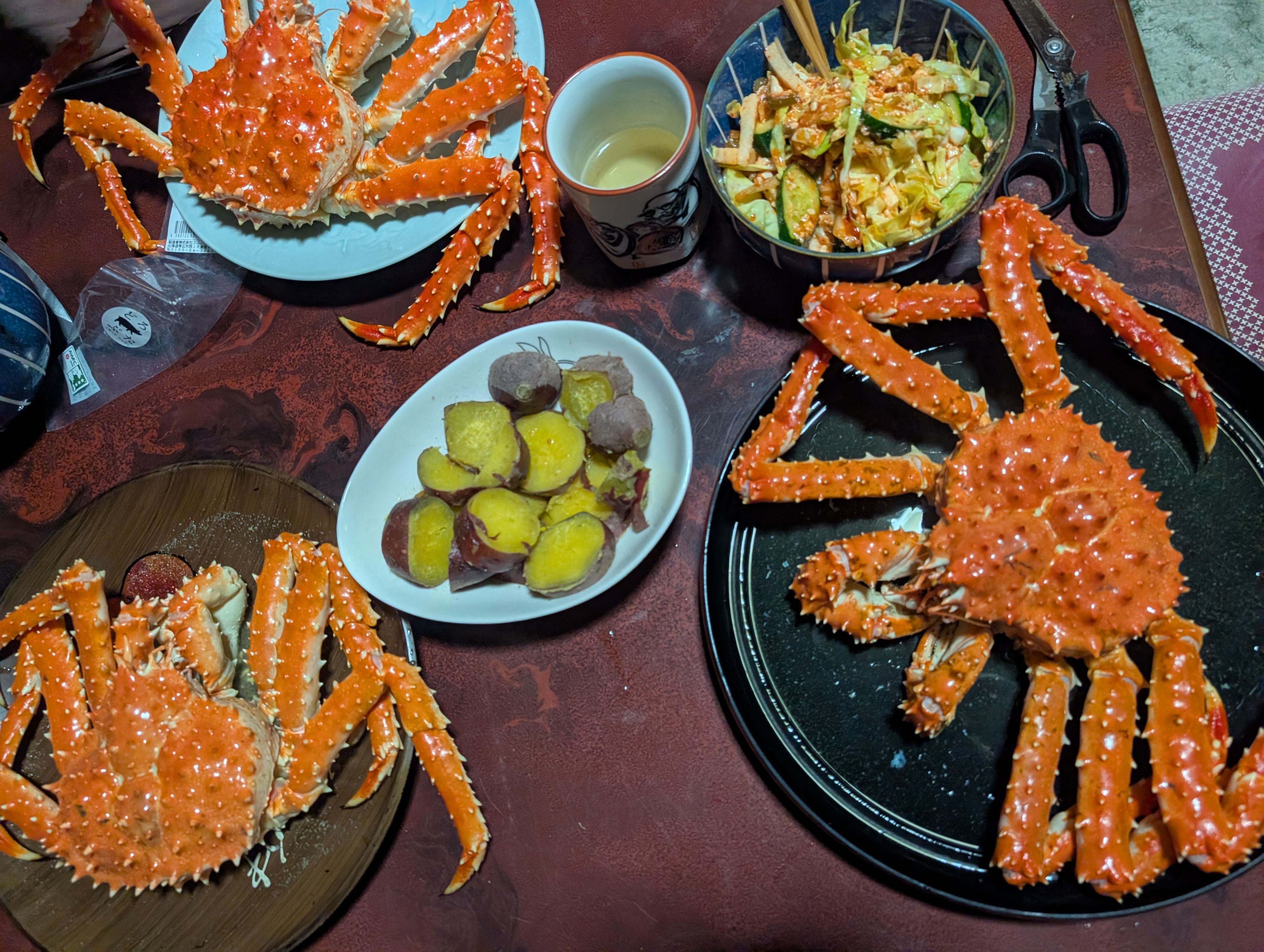 皿に盛られた大きなタラバガニと蒸したさつまいも、サラダのごちそう