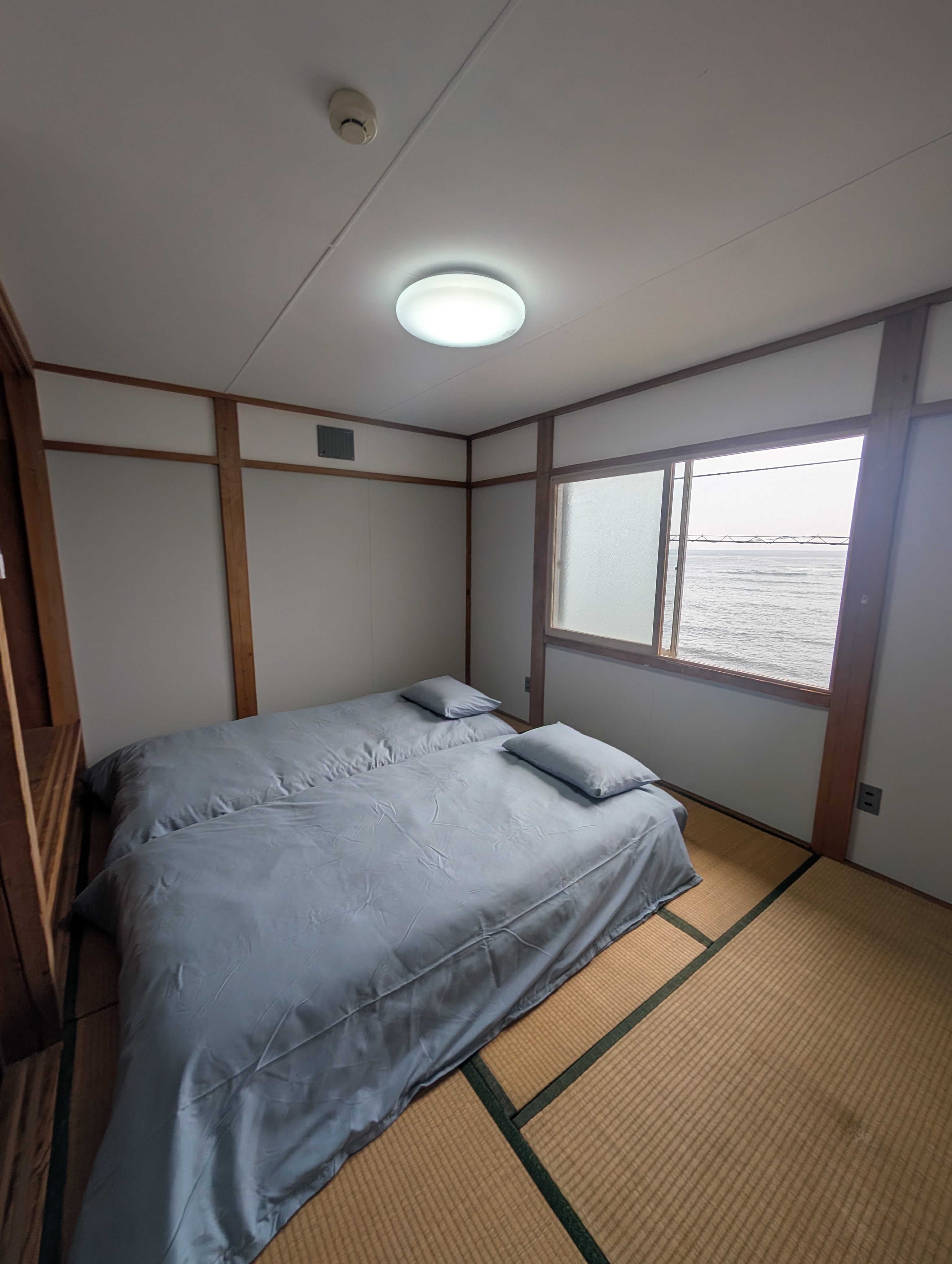 ダブルの布団と、海が見える大きな窓のある畳の部屋。